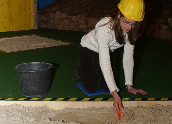 Eine Mitarbeiterin des Museum bei der Demonstration: Schicht um Schicht wird die Erde sorgfltig abgerumt