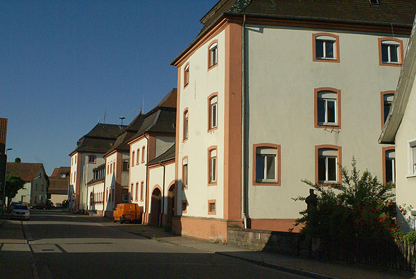 Kloster Schwarzach: Westfront der ehemaligen Abtei mit Wirtschaftsgebäuden und Klostertor