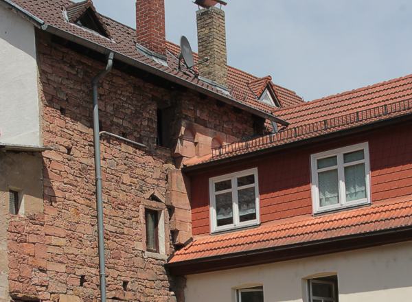 Kloster Schönau: An der Südwand eines Gebäudes im Bereich der ehemaligen Klosterkirche findet sich noch aufgehendes Mauerwerk mit romanischen Blendarkaden.