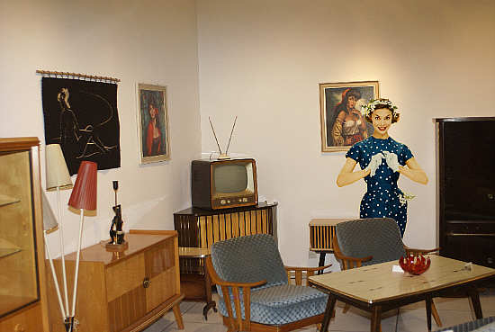 Wohnzimmereinrichtung mit Lackmöbeln, montiert mit einem Titelmodell von Burda Moden (1957)