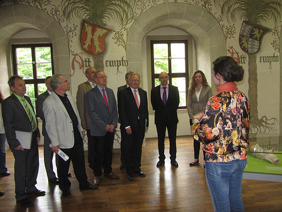 Staatssekretär Hofelich (3.v.r.) und Schlösser-und-Gärten-Geschäftsführer Michael Hörrmann (2.v.r.) im Palmensaal des Schlosses in Bad Urach.