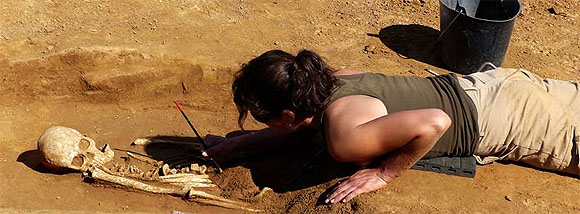 Archäologin bei der Freilegung eines menschlichen Skeletts