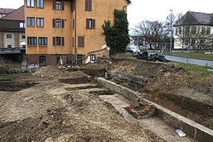 Übersicht über den nördlichen Bereich des Grabungsareals mit dem Mühlkanal. Im Hintergrund das noch nicht abgebrochene Haus Alleenstr. 26 und hinten rechts Schloss Kirchheim. Foto: Archäologie-Zentrum GmbH