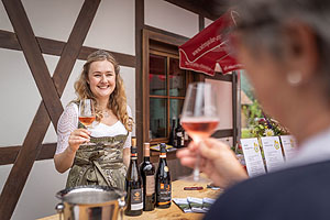 Eine Frau schenkt verschiedene Weinproben aus