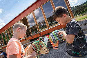 Zwei Kinder mit selbst gebastelten Steckenpferden