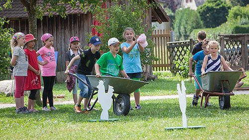 Sommerferienprogramm: Das Freilichtmuseum Vogtsbauernhof bietet in den Sommerferien in Baden-Württemberg ein buntes Mitmachprogramm mit täglichen Aktionen an. So können die kleinen Museumsgäste beispielsweise alte Kinderspiele ausprobieren.